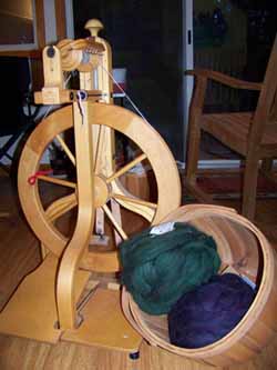 Schacht Spinning wheel with basket of green and purple fiber